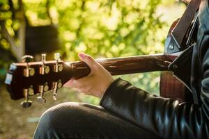 Man playing guitar in nature on a sunny day photo