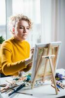 Portrait of an artist girl who creates a painting at home photo