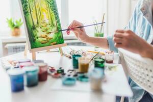 hermosa niña artista pinturas en lona a hogar foto