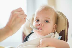 mother feeding her baby breast porridge day photo