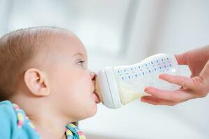 mother feeds her nine-month baby milk house photo