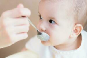 Mom feeds her nine months baby at home photo