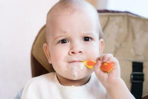 baby holding a spoon in his mouth photo
