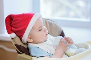baby drinking milk in Christmas red hat photo