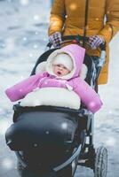 Mom stands near the stroller with a child photo