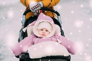 Mom stands near the stroller with a child photo