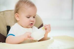 Kid eats porridge hands of the plate photo