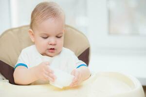 niño come gachas de avena manos de el plato foto