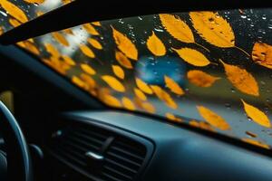 Autumn leaves and raindrops on the windshield of a car. Inside view. selective focus. generative ai. photo