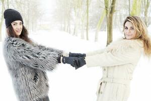 mother and daughter holding hands in the snow photo