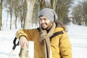 young man relaxes before shoveling snow photo