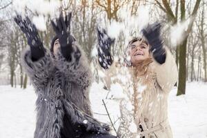 happy mother and daughter throwing snow in the air in the park photo