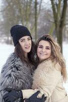 mamá y hija abrazando cada con amor en el nieve foto