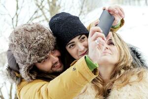 group of person taking selfie in winter forest photo