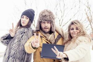 group of friends makes victory sign in the snow photo