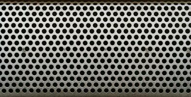 close up of a metal grate with small round holes - background for use as a texture photo