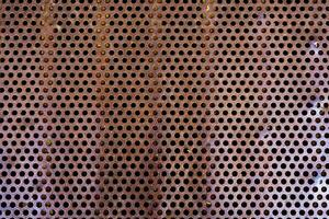 close up of a metal grate with small round holes - background for use as a texture photo