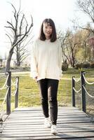 young Chinese girl relaxes in an outdoor park photo