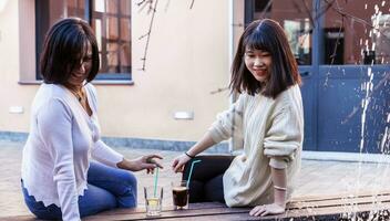 young female friends take an aperitif outdoors photo