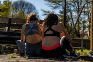 beautiful middle aged women planning workouts at the computer outdoors photo