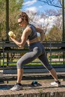 beautiful middle aged woman training with dumbbells outdoors photo