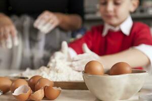 little boy having fun and prepare the dough for cookies photo