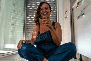 image of a beautiful middle aged woman drinking a cocktail sitting in her apartment photo