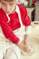 cute child in the kitchen while mixing the dough photo