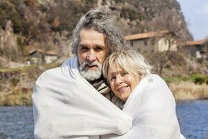 beautiful mature couple relaxing sitting on the dock photo