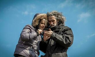 mature man photographing his partner outdoors photo