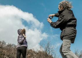 mature man photographing his partner outdoors photo