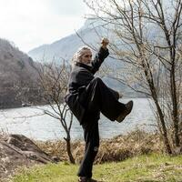 maduro hombre practicando Tai chi disciplina al aire libre foto