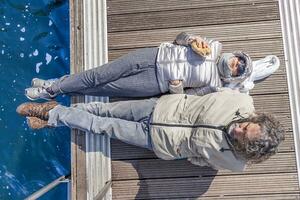 hermosa maduro Pareja relajante acostado en el muelle foto