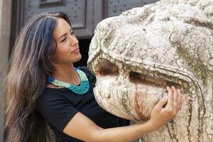 retrato de bonito niña abrazo un mármol león foto