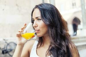 portrait of attractive girl while drinking an orange juice photo