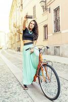 pretty young girl with a bike takes a selfie around town photo