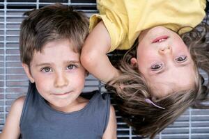 retrato de Gemelos Niños y muchachas acostado en un metal rallar foto