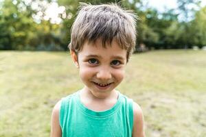 retrato de linda sonriente chico en un público parque foto