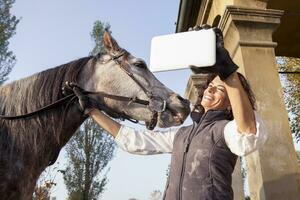 horsewoman takes a selfie with his horse to the country roads in autumn photo