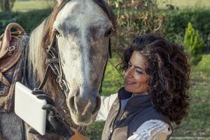 horsewoman takes a selfie with his horse photo