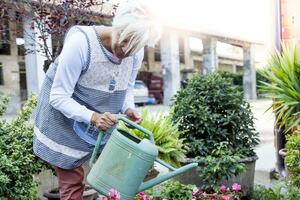 atractivo ama de casa riego su flores con amor foto