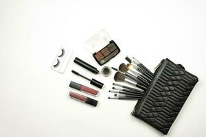 Handbag with makeup set and tools on white photo