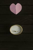 Offer of marriage. Flat lay romantic background. Red paper heart and giftbox with a golden ring photo