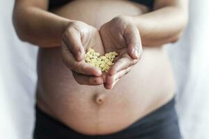 pregnant woman holding pills or drugs photo