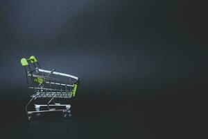 mini supermarket shopping cart on black, holiday sale and online shopping concept photo