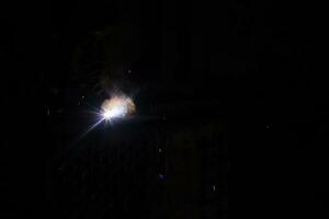 A worker man with protective mask welding metal photo