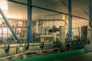 Glass bottles on the automatic conveyor line at the champagne, beer or wine factory. Plant for bottling alcoholic beverages. photo