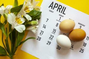 April 2020 Easter monthly calendar with colorful eggs and spring flowers photo