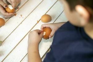 6 years old child cleans the shell of the Easter eggs photo