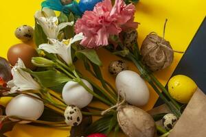 Bright spring flowers bouquet with colorful easter eggs photo